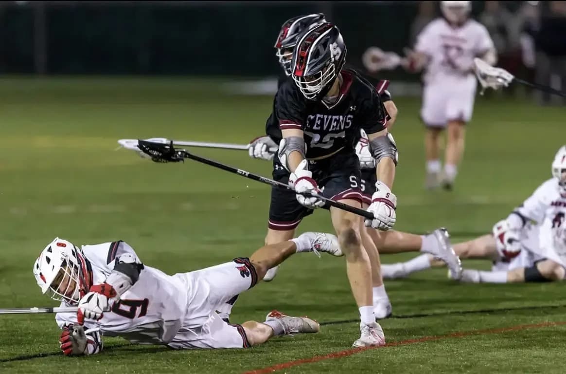 Dan Crotty in his Stevens Ducks jersey, dispossessing an opposing attackman with a textbook check